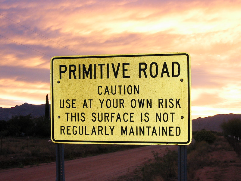 Sign proclaiming the road in Cochise, Arizona, to be both primitive and without maintenance.